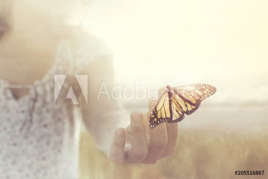 Picture of A butterfly leans on a hand of a girl in the middle of nature